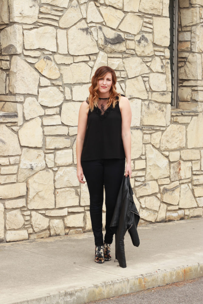A black lace top with a fringe clutch and floral boot.